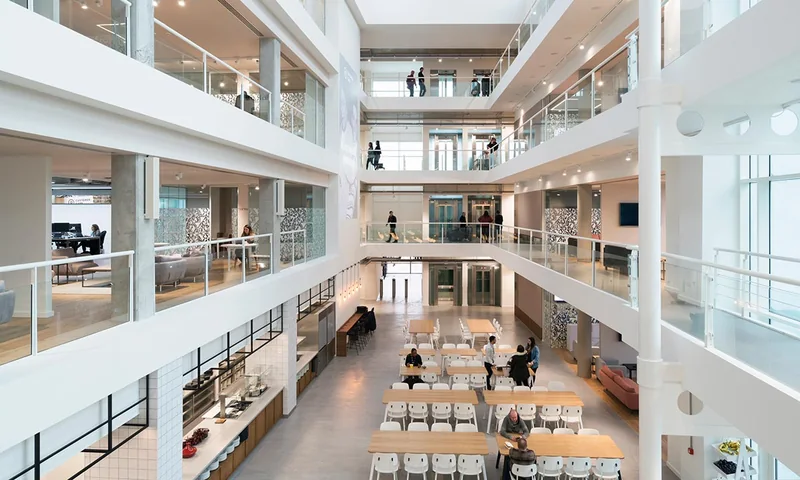 A multi storey office atrium with balustrading, glazed screens and internal doors