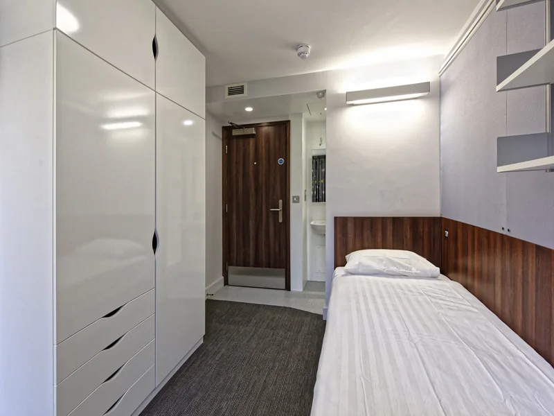 A corridor of matching flush doors in a residential building